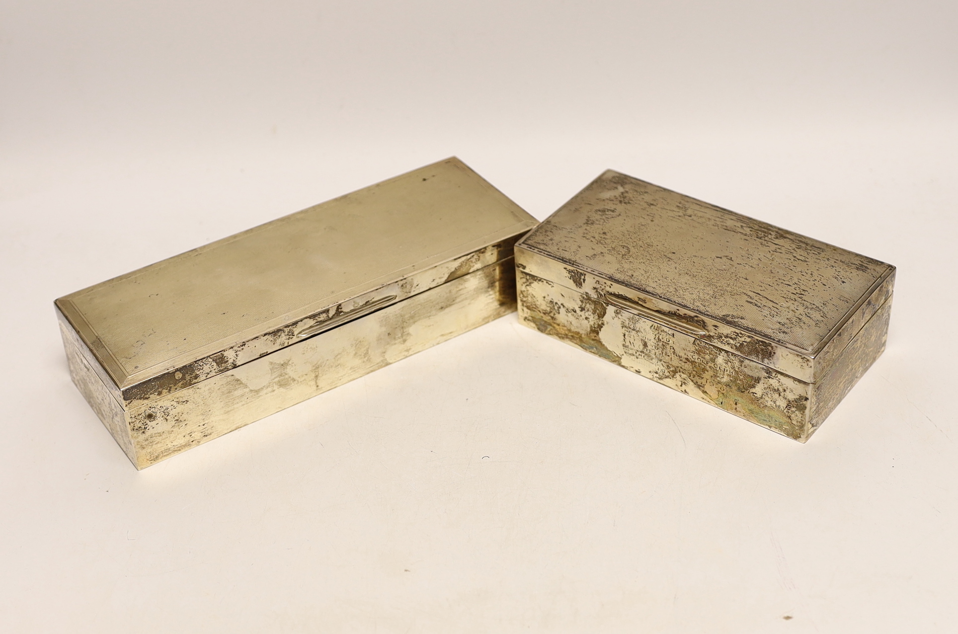 Two mid 20th century engine turned silver rectangular cigarette boxes, largest 24.2cm.